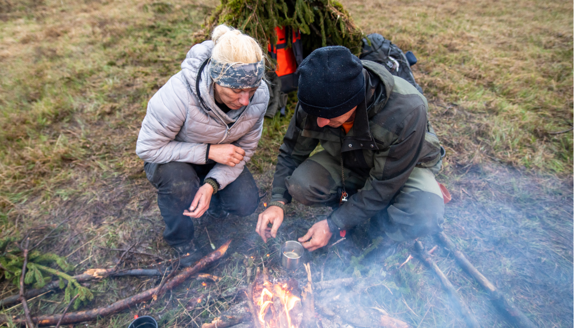 wilderness-survival-bonfire-woman-man-heating-water-using-metal-cup